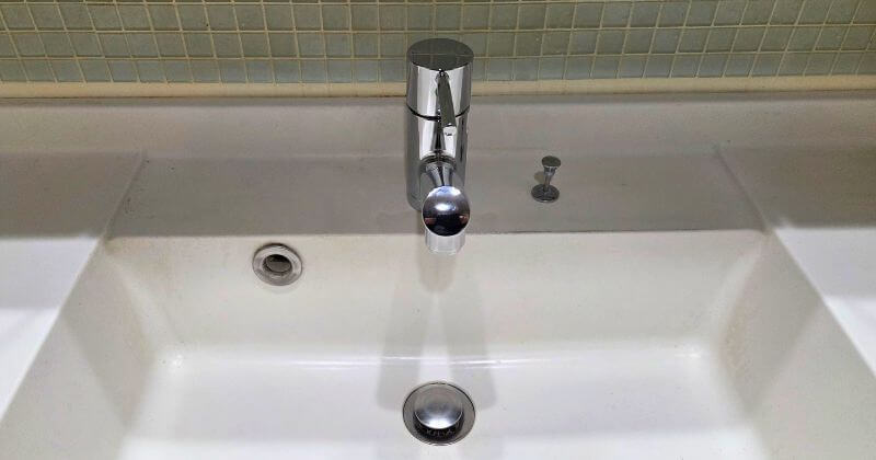 新しい洗面水栓の取付中